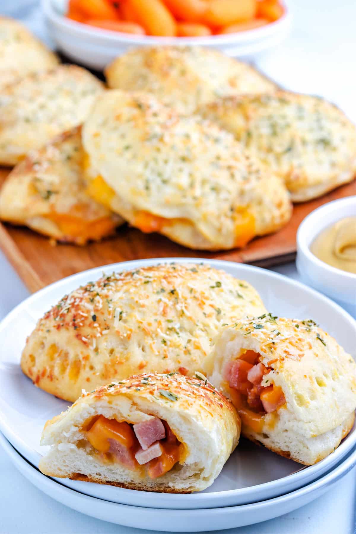 Two Ham and Cheese Hot Pockets on a plate and one broken in half.