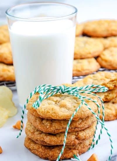 A stack of four Potato Chip Cookies with a glass of milk in the background.