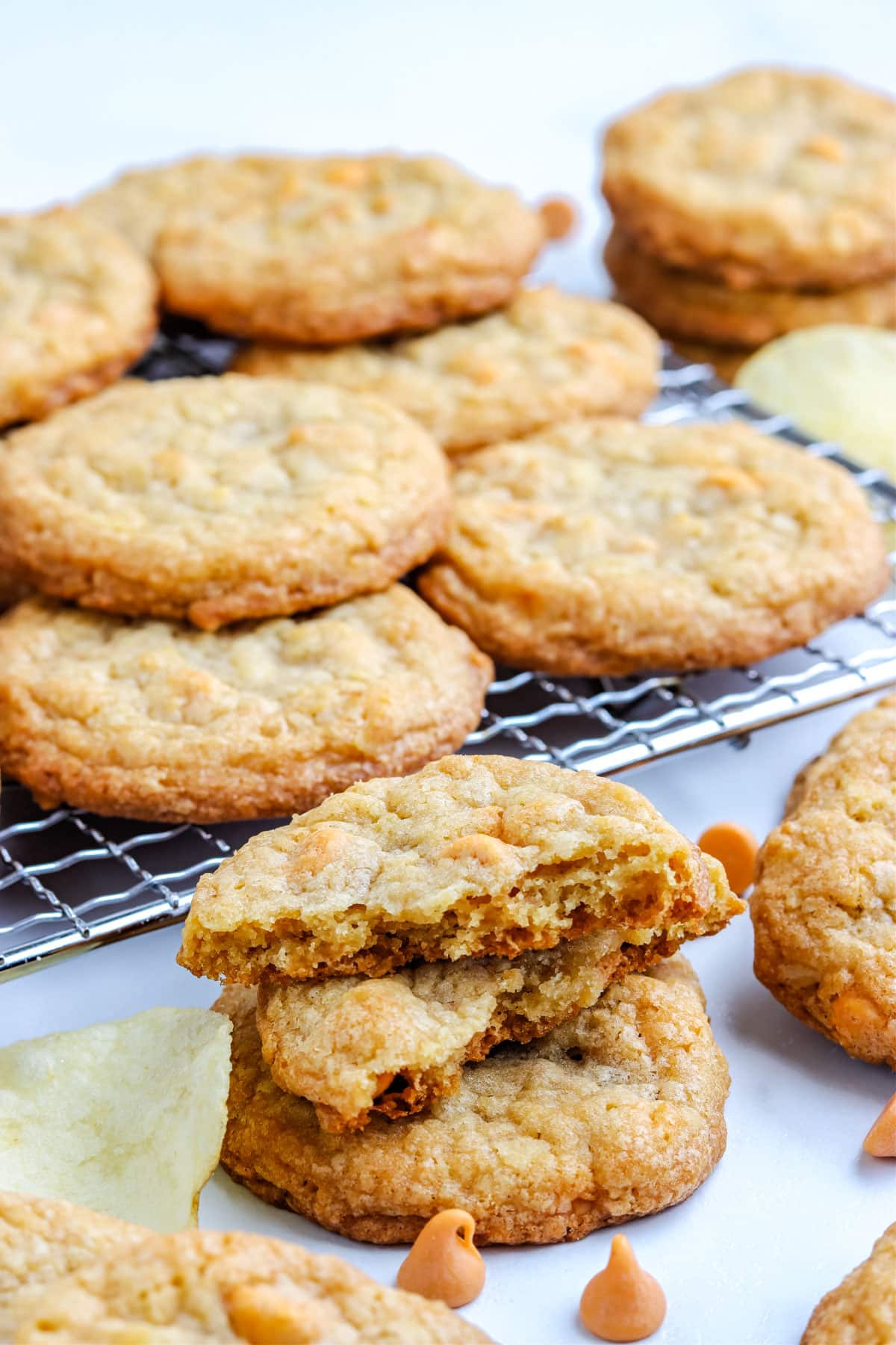 A stack of Potato Chip Cookies with more in the background on a wire rack. 