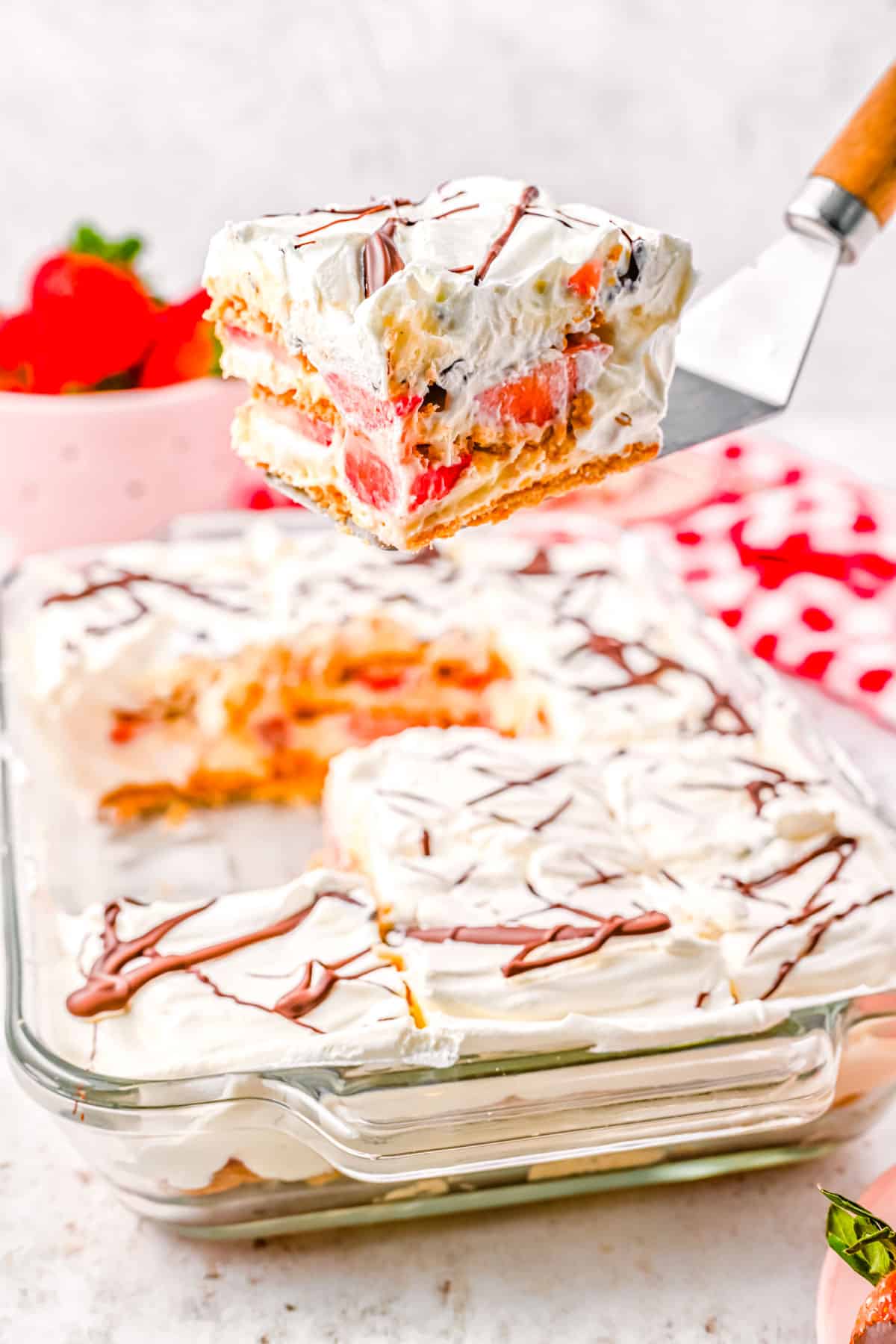 A piece of the finished Strawberry Icebox Cake recipe being lifter with a spatula.