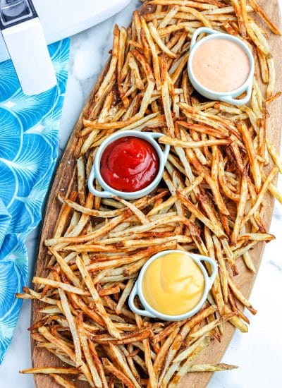 An overhead picture of the finished Air Fryer French Fries on a Woden serving board.