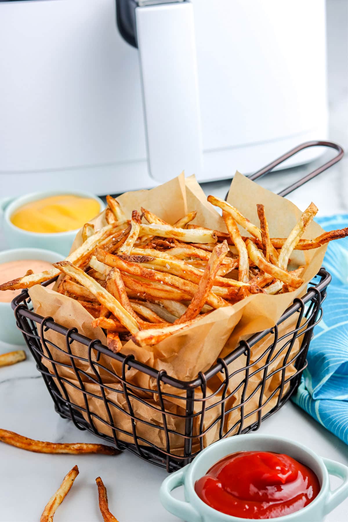 French fries made in an air fryer in a serving basket.