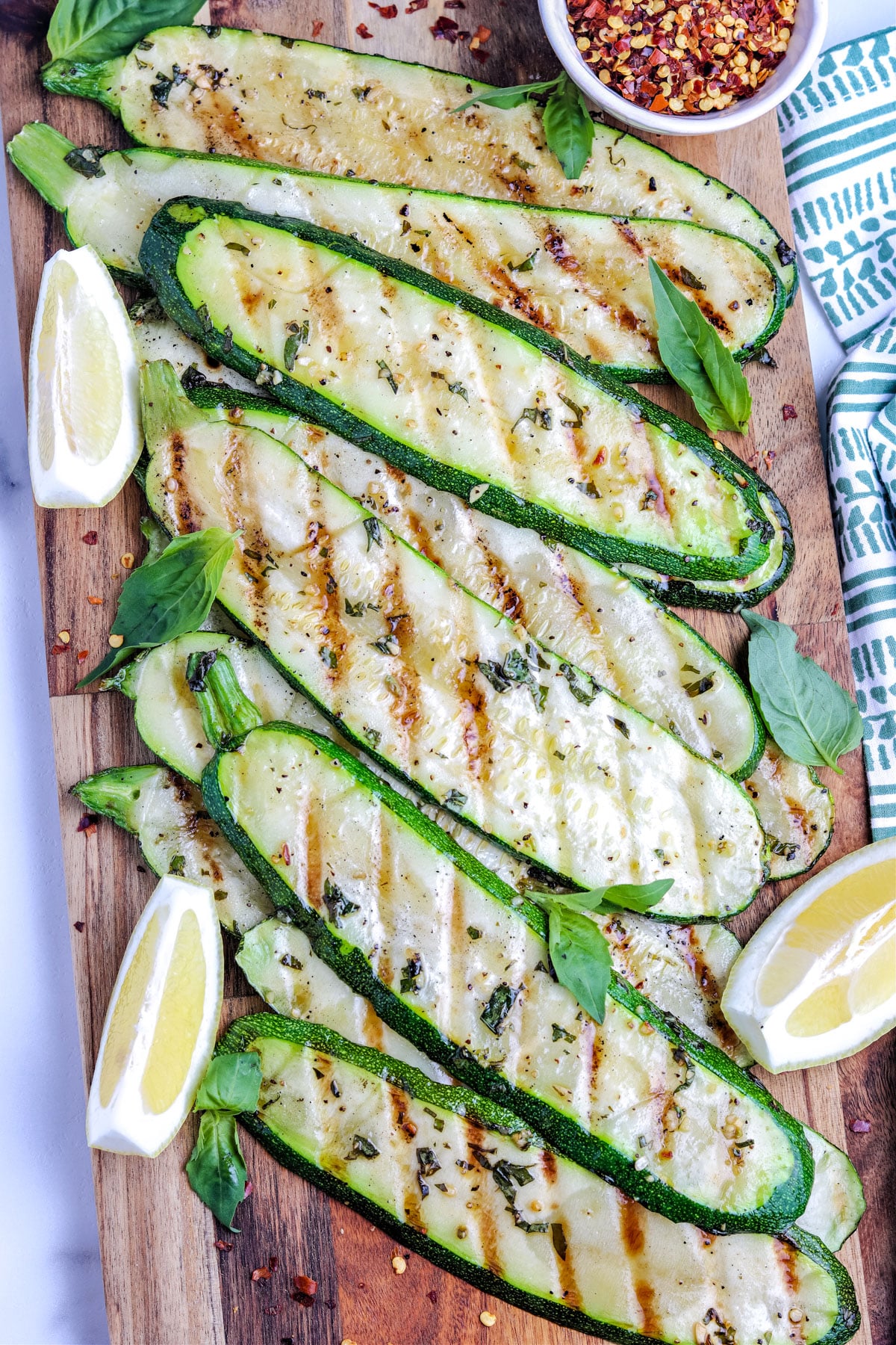 An overhead picture of Grilled Zucchini on a wooden serving board. 