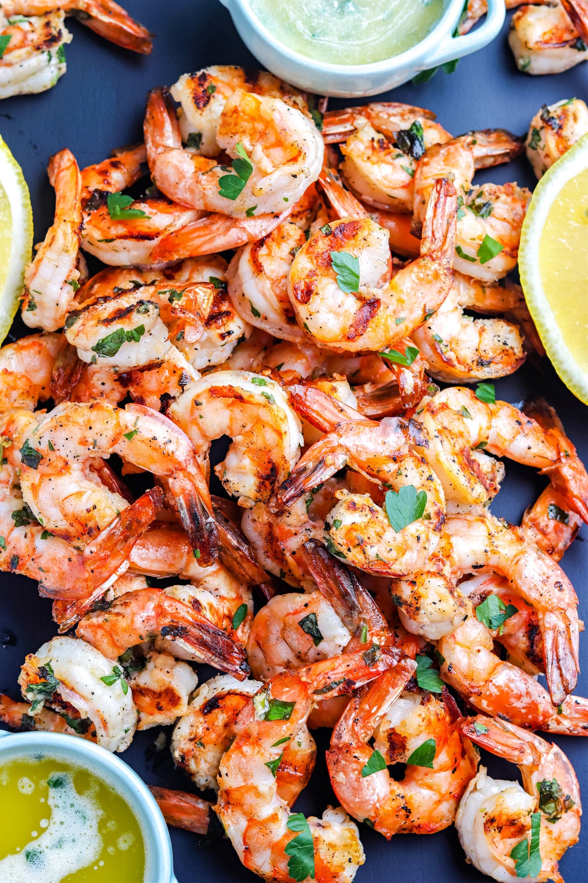 A close up overhead picture of shrimp on a black platter.