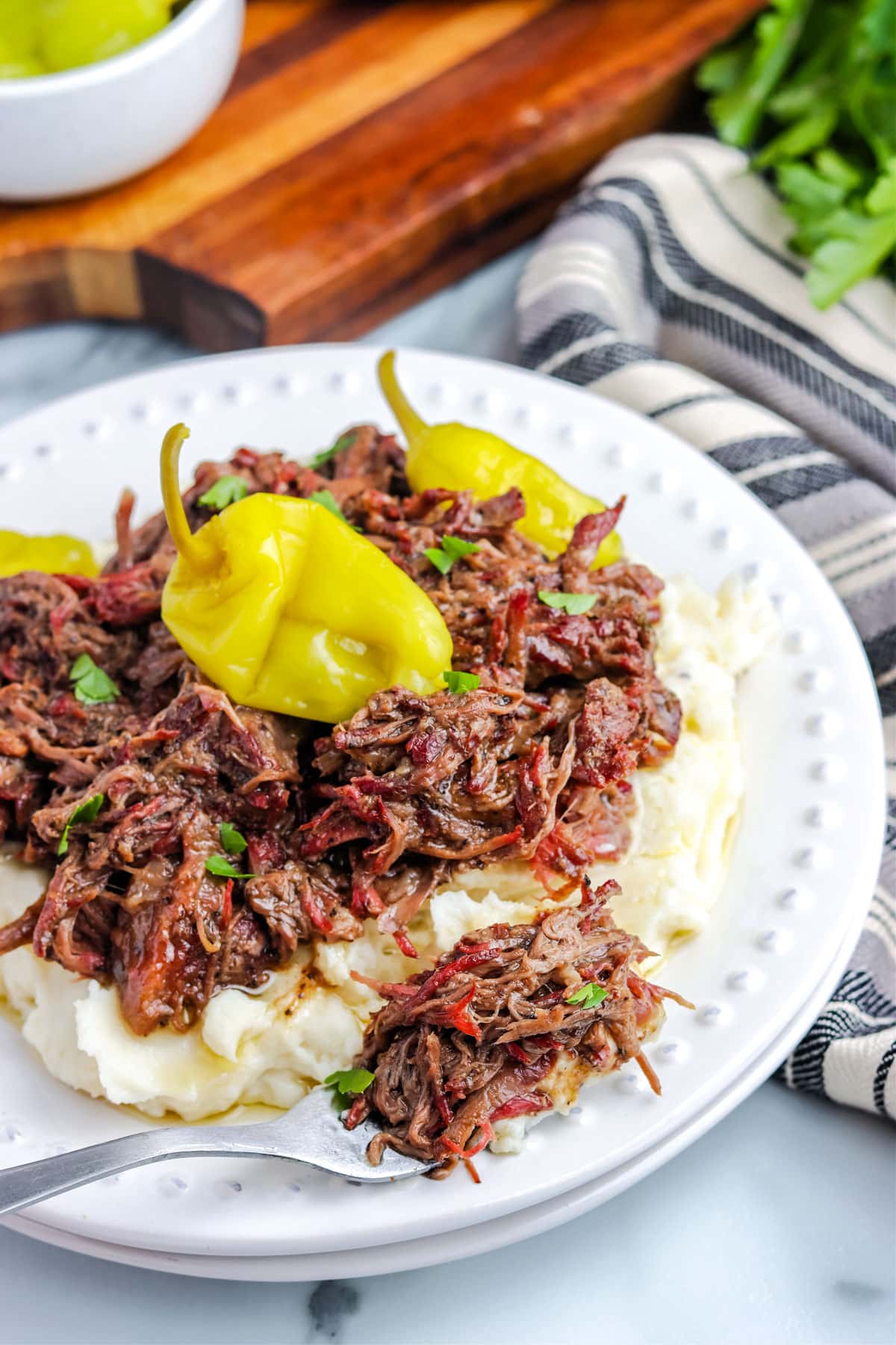 A fork picking up some Mississippi Pot Roast off of a plate.