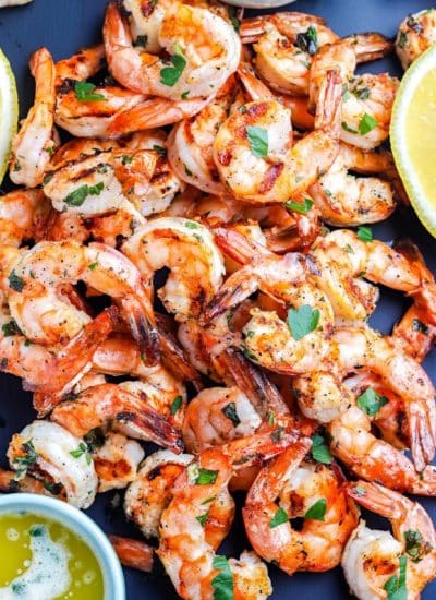 A close up overhead picture of shrimp on a black platter.