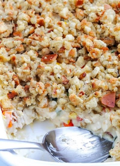 The finished casserole with a serving spoon in it scooping out some of it.