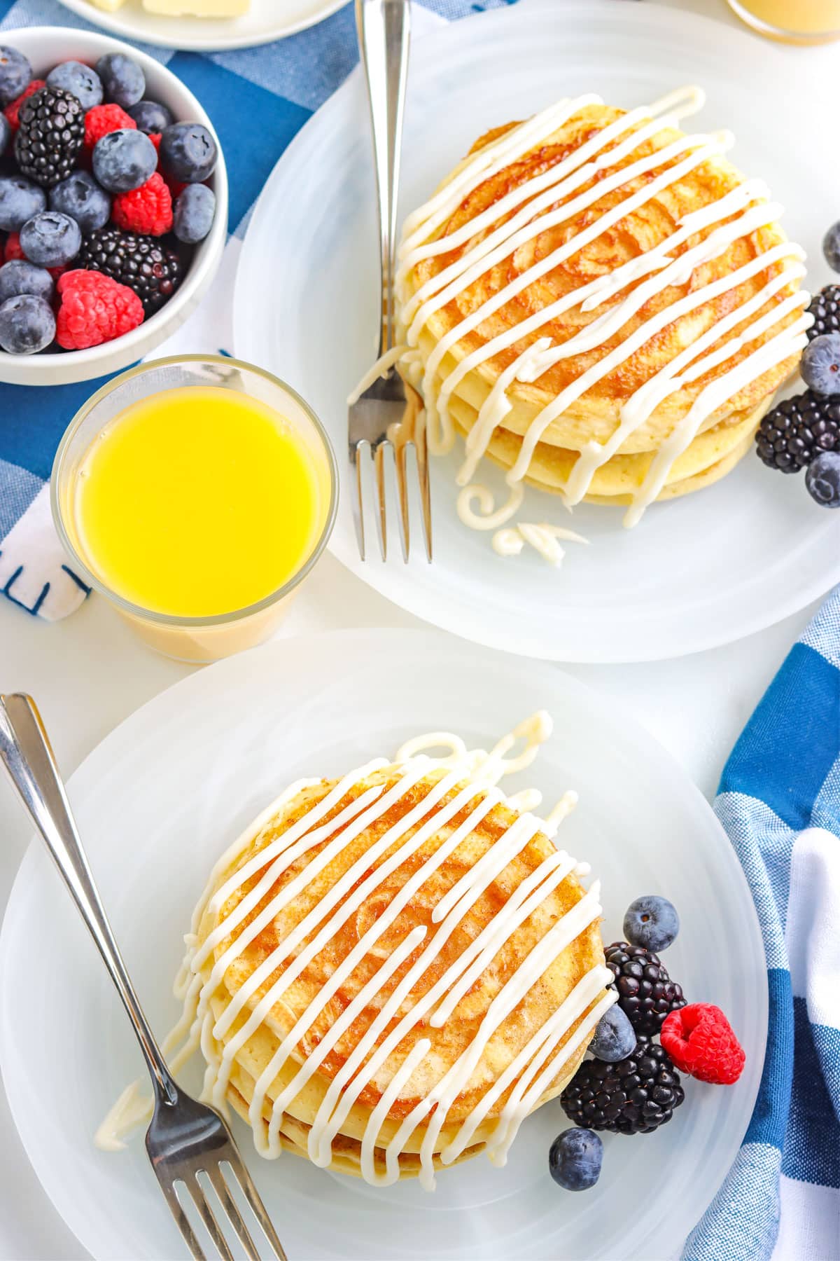 An overhead picture of two stacks on Cinnamon Roll Pancakes on white plates.