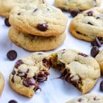 A close up of a cookie broken in half so you can see the melty chocolate chips.