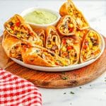 Southwest Chicken Egg Rolls on a platter with dipping sauce.