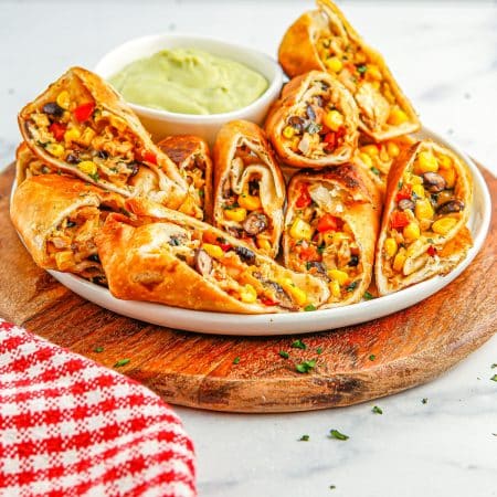 Southwest Chicken Egg Rolls on a platter with dipping sauce.