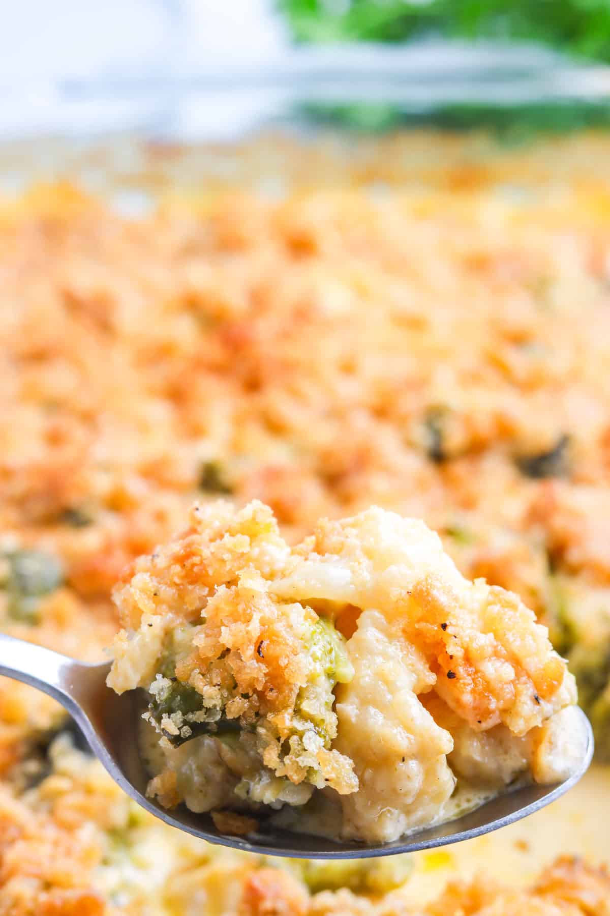 A serving spoon picking up Cauliflower Casserole from the casserole dish.