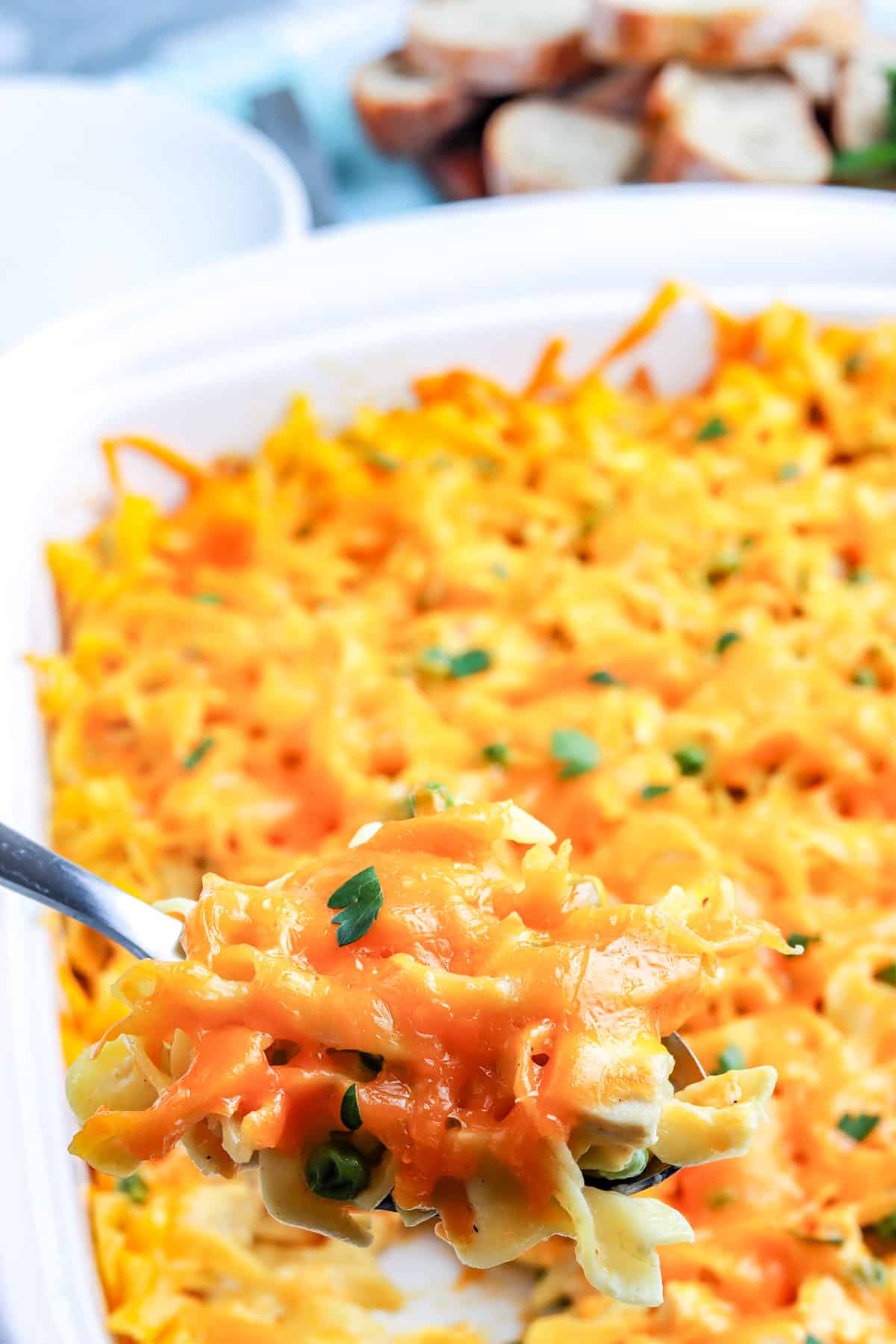 A spoon scooping up some of the finished chicken casserole with noodles.