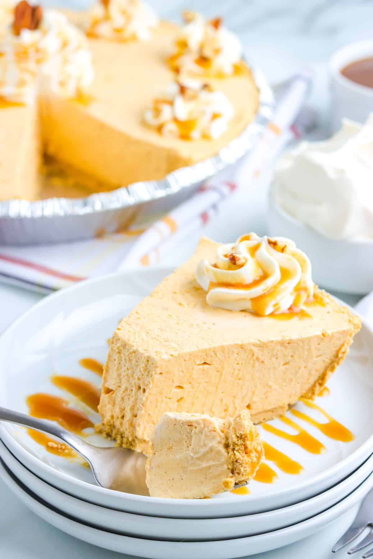 A slice of No Bake Pumpkin Cheesecake Pie on a white plate.