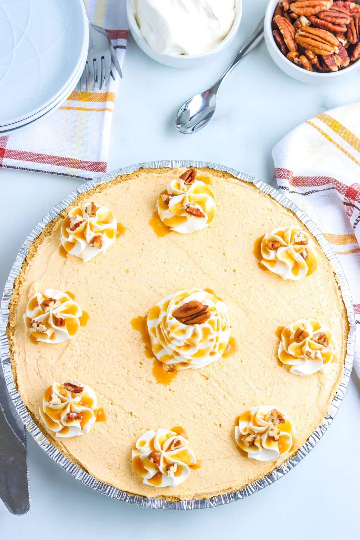 An overhead picture of the finished No-Bake Pumpkin Pie garnished with whipped cream, caramel, and pecans.
