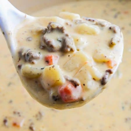 A ladle picking up some of the recipe for Cheeseburger Soup.