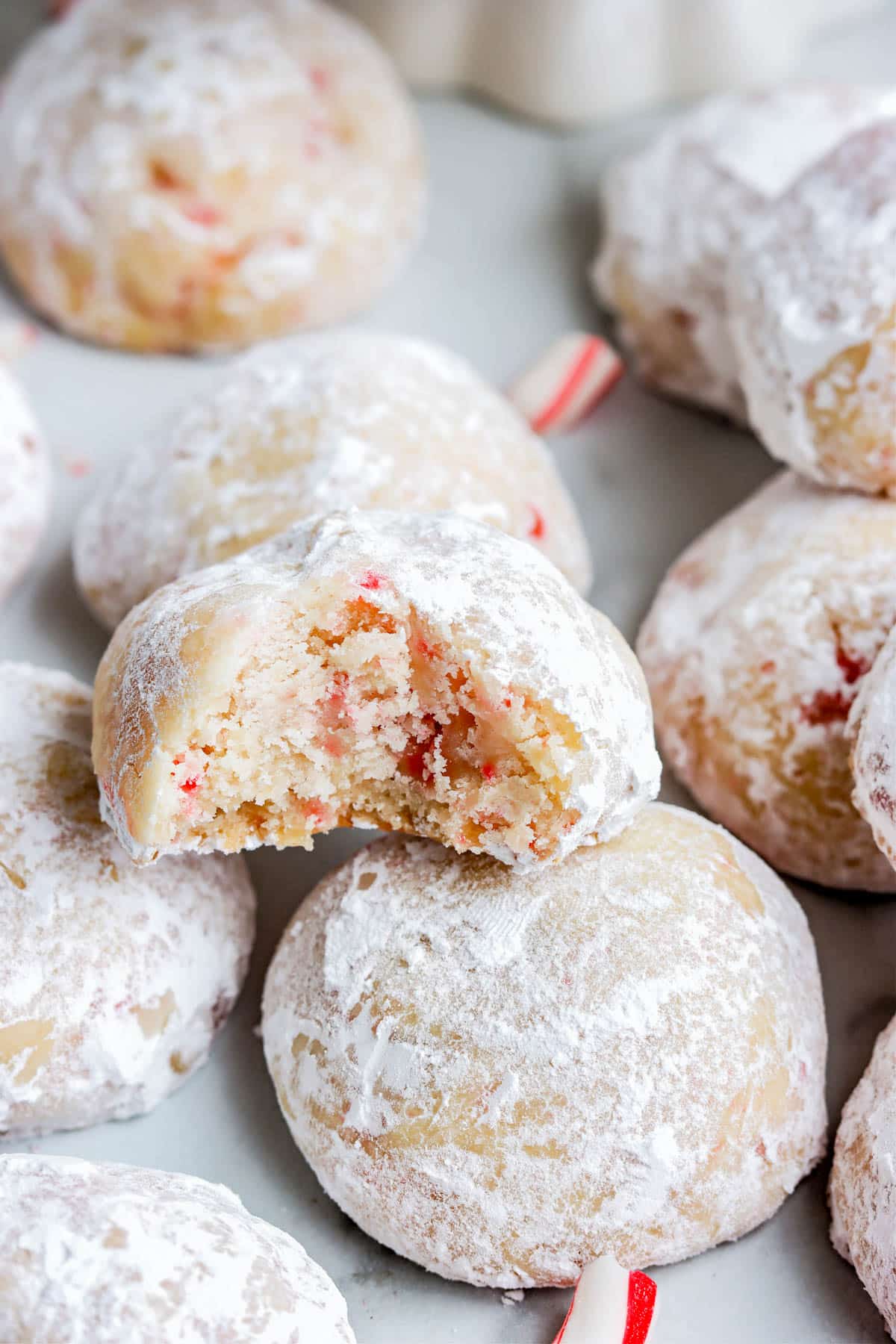 A Peppermint Snowball Cookie bit into so you can se the inside of the cookie. 