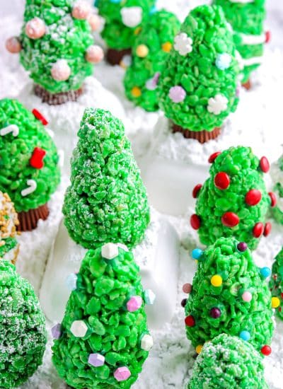 Decorated Rice Krispie Christmas Trees on a wooden table.