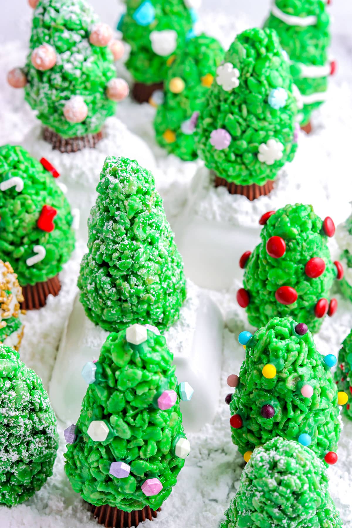 Decorated Rice Krispie Christmas Trees on a wooden table. 
