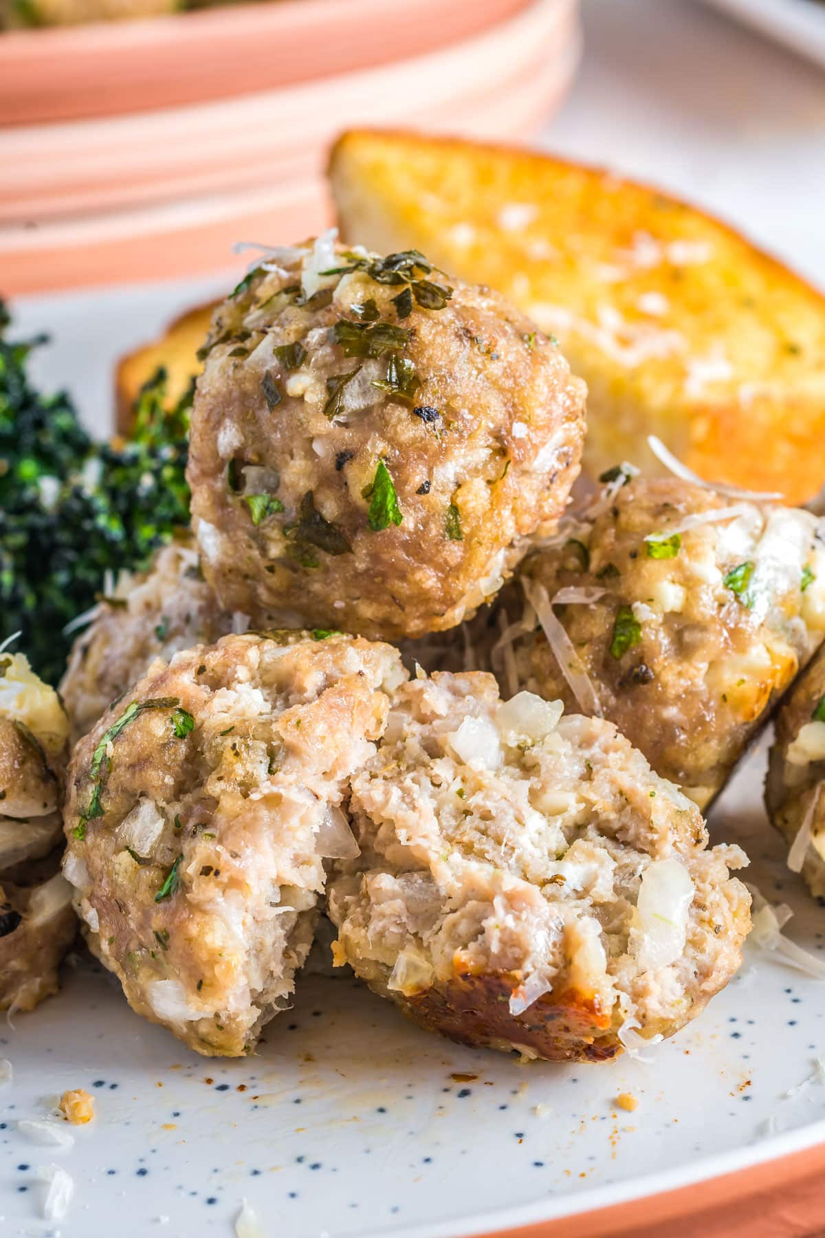 A close up of three Turkey Meatballs on a plate and one is cut in half. 