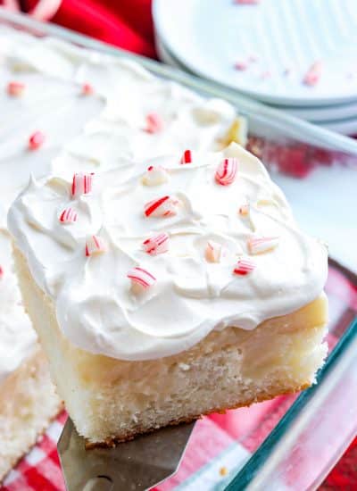 A piece of White Chocolate Peppermint Poke Cake being taken out of the pan.