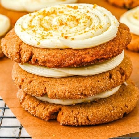 Three frosted gingerbread cookies stacked on top of each other.