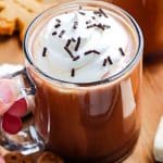 A mug os Gingerbread Hot Chocolate garnished with whipped cream and chocolate sprinkles.