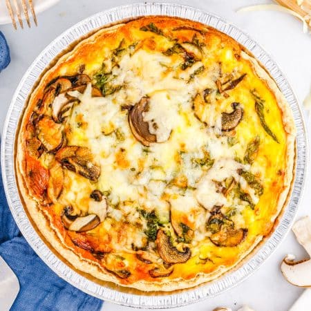 The finished mushroom spinach quiche on a tabletop.