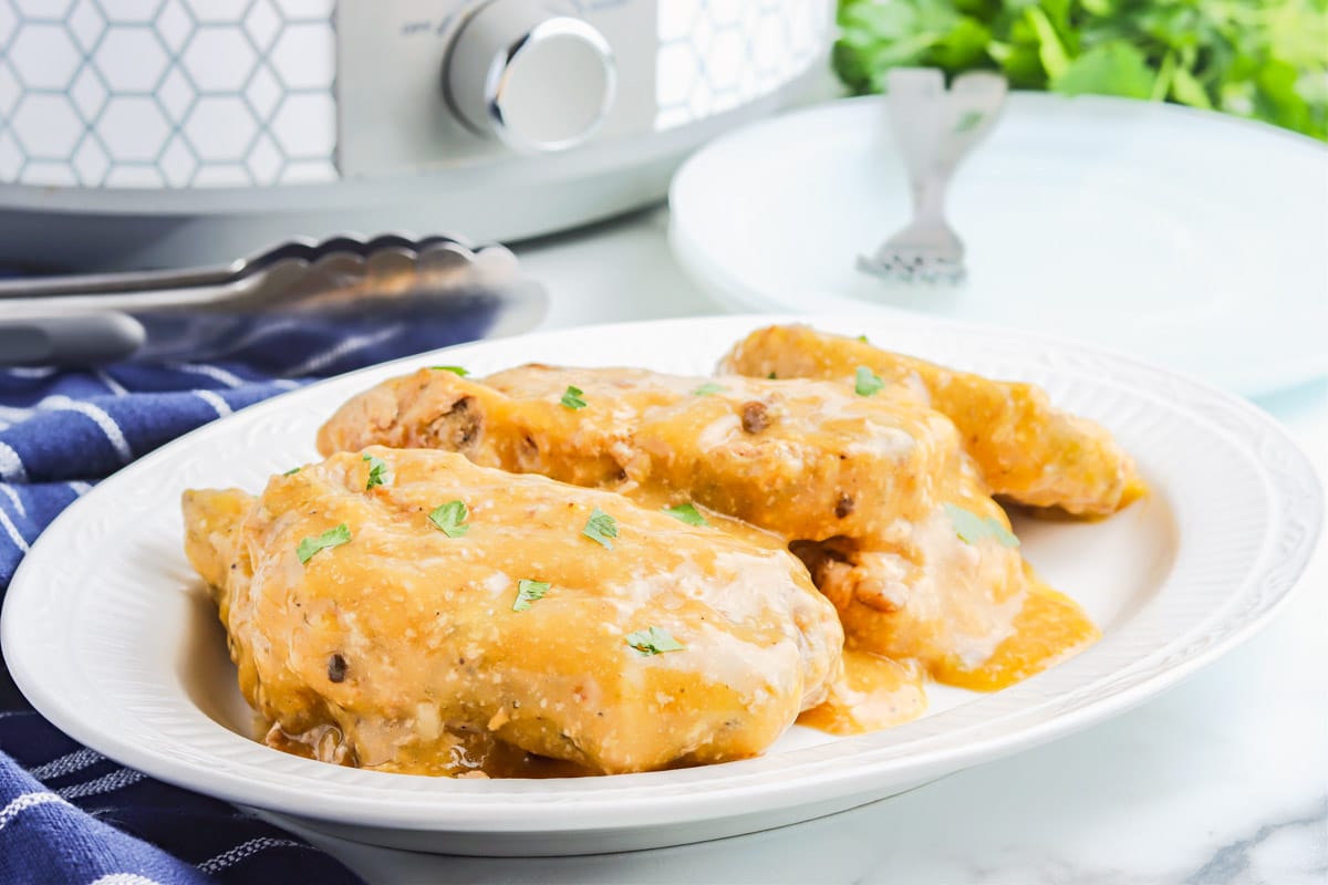 Two of the finished slow cooker ranch pork chops on a white plate.