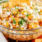 A close up of the finished Mexican Street Corn Dip in a glass bowl.