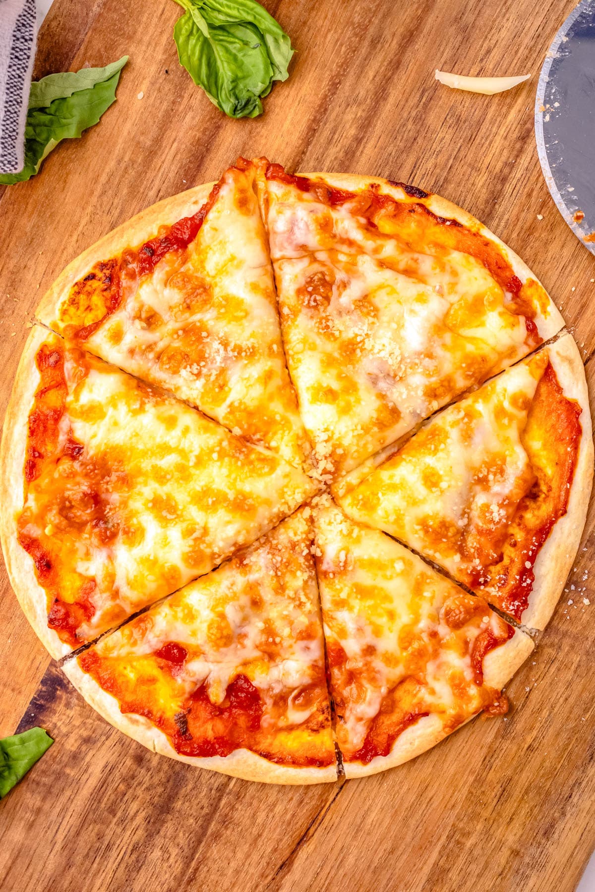 The finished Air Fryer Tortilla Pizza on a wooden cutting board. 