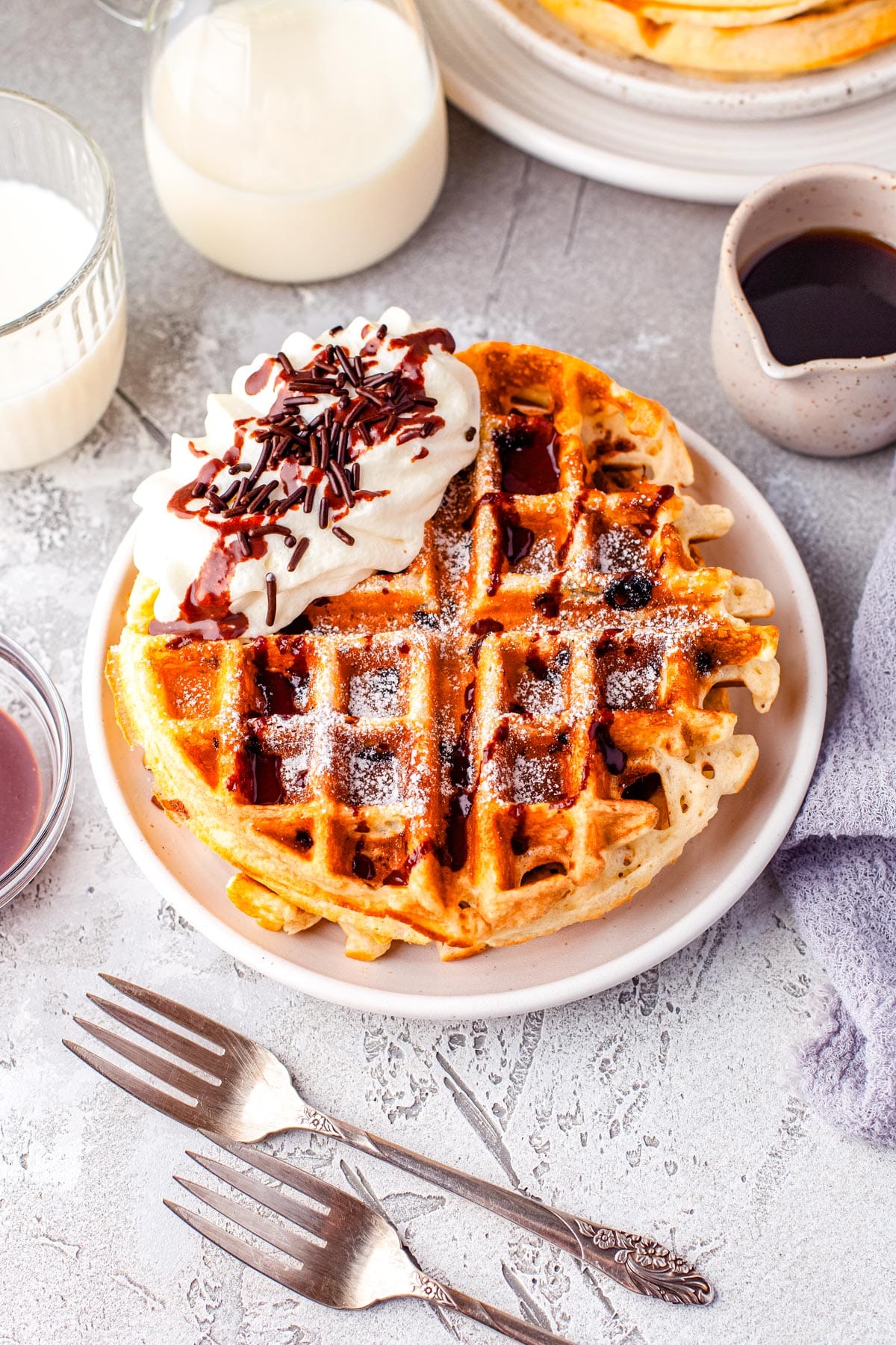 Two of the finished Chocolate Chip Waffle recipe on a white plate.