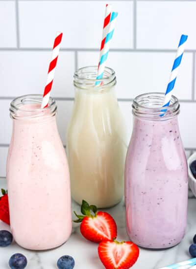 The finished drinkable yogurt in glass bottles with paper straws.