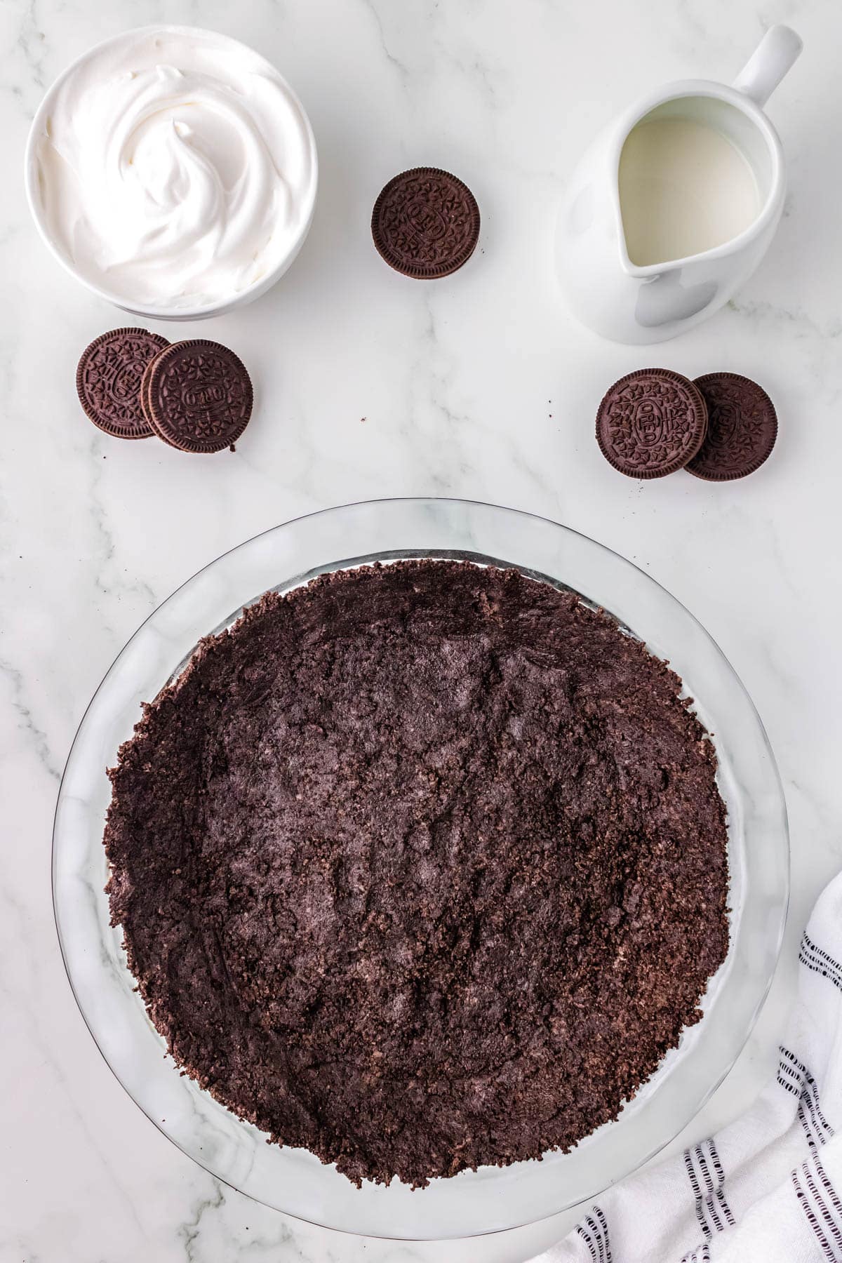 The finished Oreo Pie Crust in a clear Pyret pie plate. 