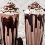 Two milkshakes in clear glasses.