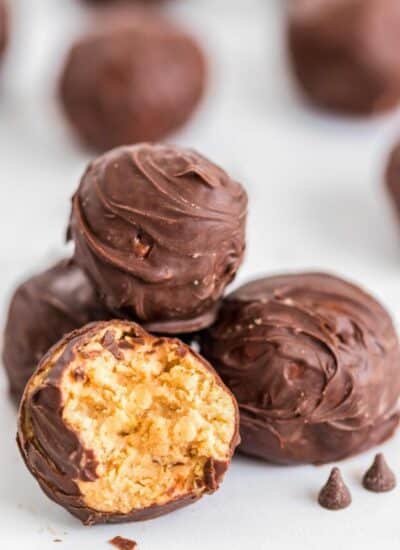 Chocolate Peanut butter bon bons. One ball has a bite revealing the peanut butter and rice Krispy center.