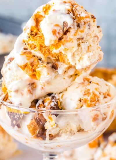 A close up of of three scoops on Butterfinger ice cream in an ice cream dish.