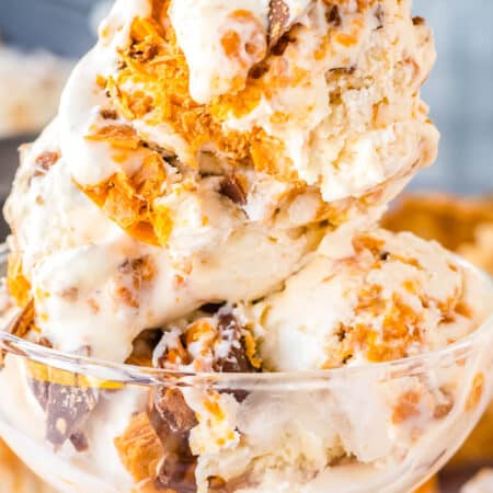 A close up of of three scoops on Butterfinger ice cream in an ice cream dish.