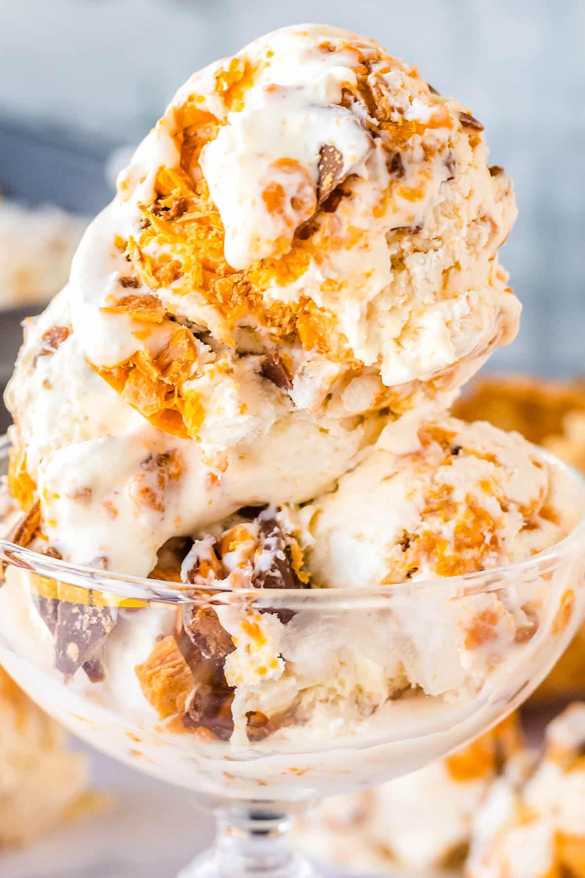 A close up of of three scoops on Butterfinger ice cream in an ice cream dish.