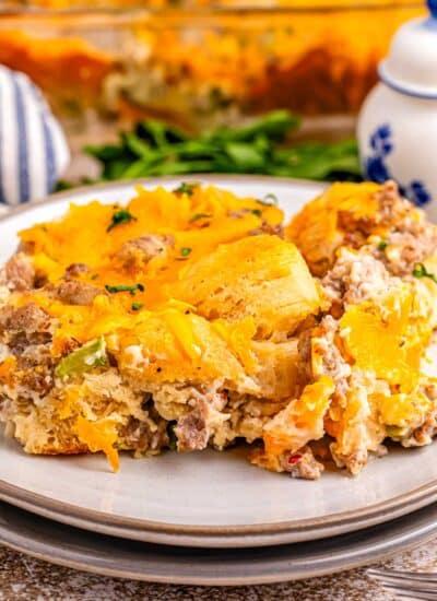 A slice of biscuits and gravy casserole on a white plate.