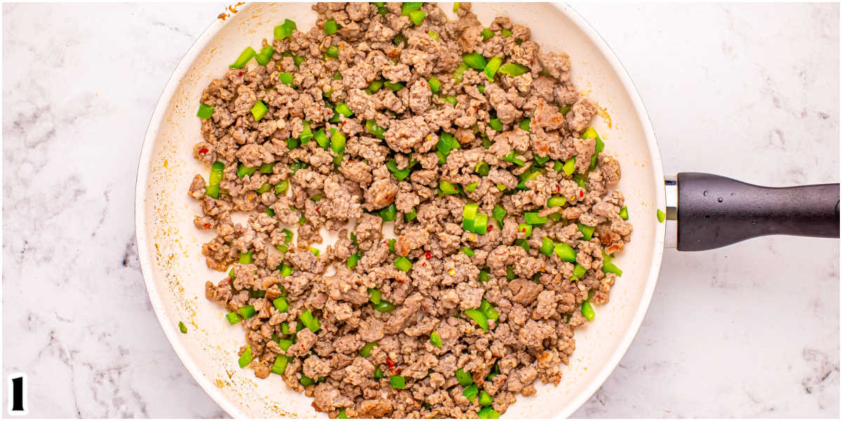 The cooked sausage and green bell pepper in a pan.
