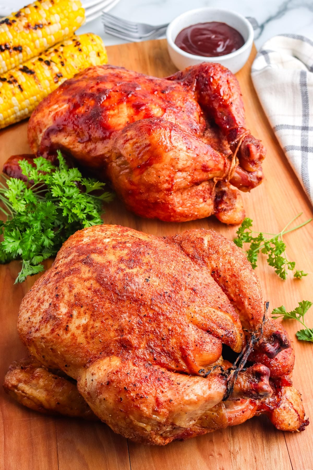 The finished Smoked Whole Chicken recipe on a cutting board. 