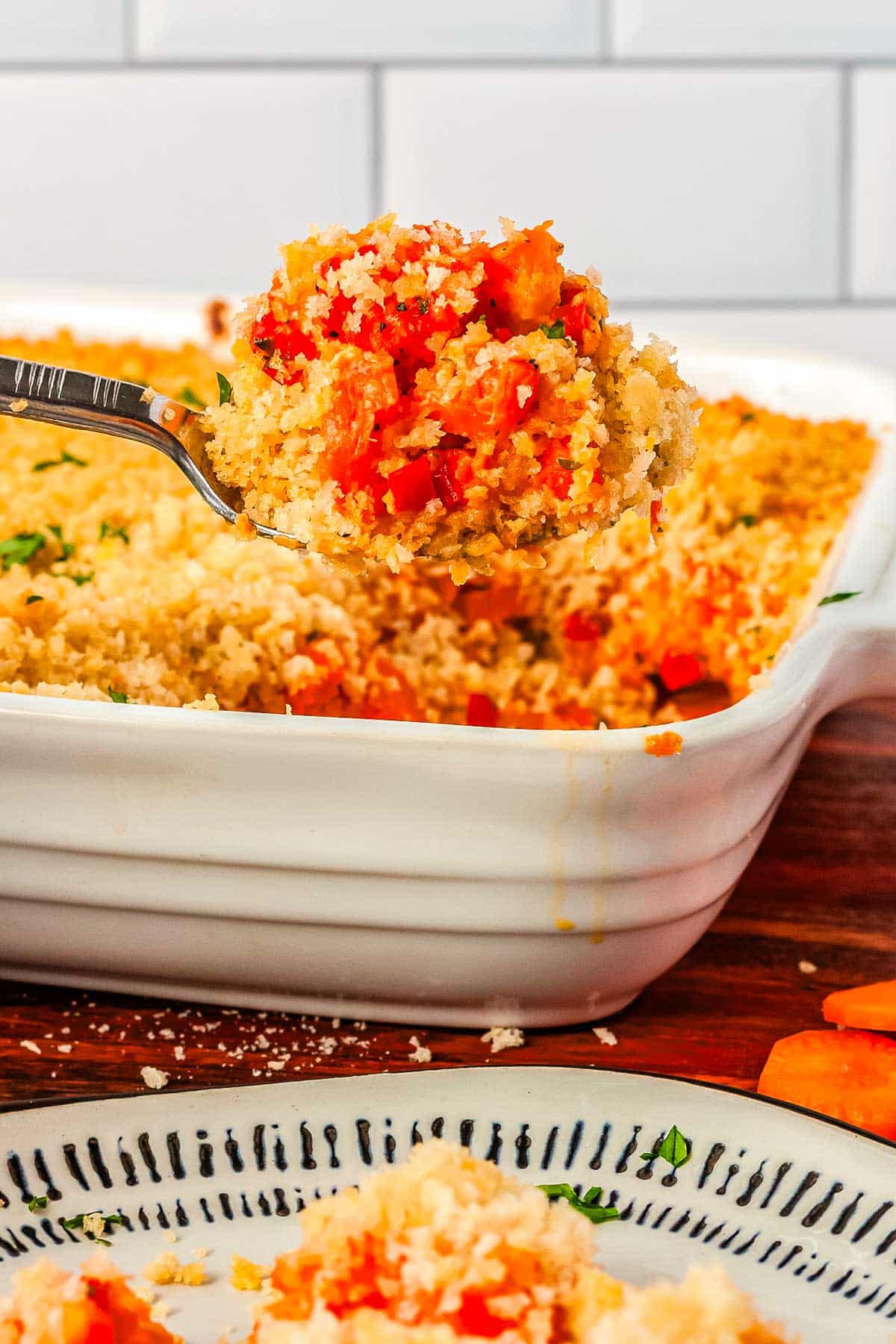A serving spon scooping up some of the finished carrot casserole. 