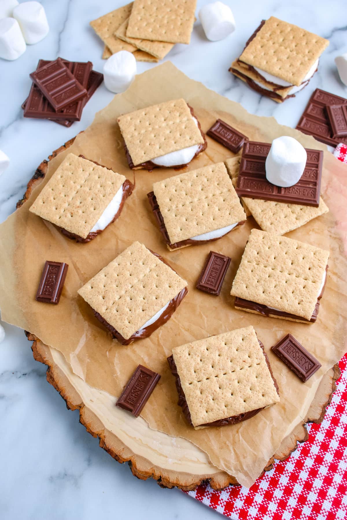 A tray of grilled s'mores with chocolate and marshmallows in the background
