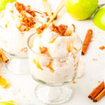 two glass dishes of apple pie ice cream with apples in the background